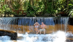 Couple sitting under the waterfall at Tabacon Hot Springs